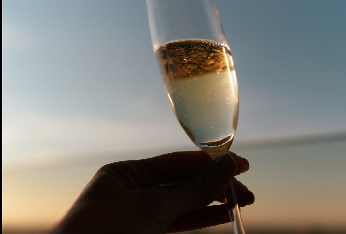 A glass of Saysah held up to the sunset