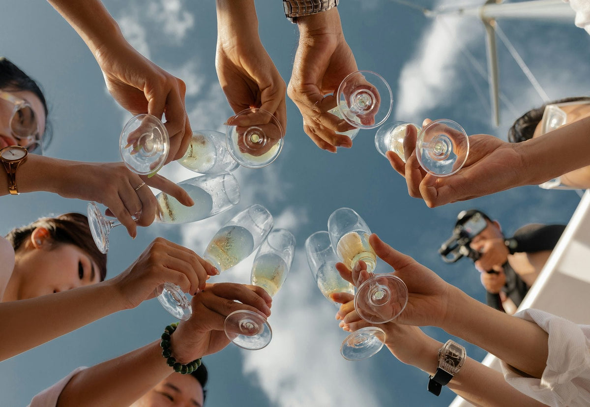 Hands raising glasses of sparkling wine in a toast
