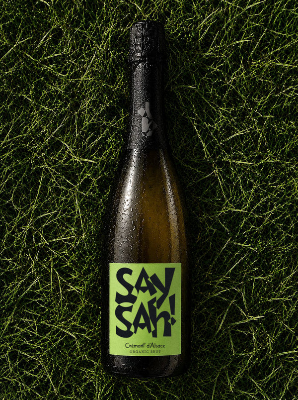 A bottle of Saysah Organic Brut on grass