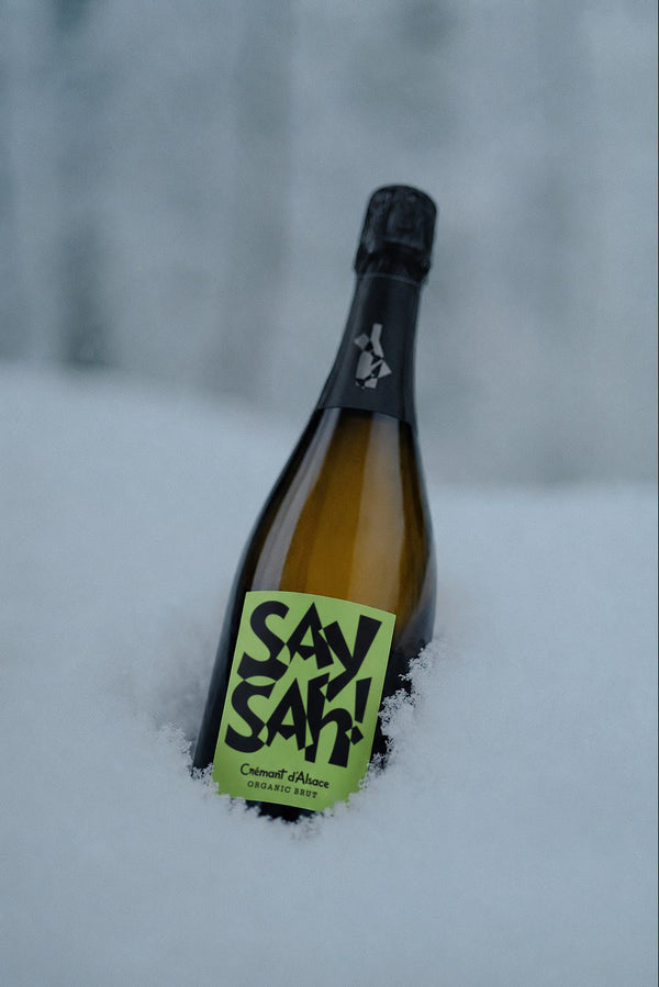 A bottle of Saysah Organic Brut in fresh snow